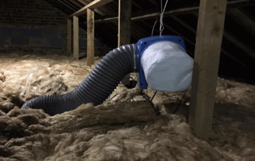 Worker installing insulation in attic space